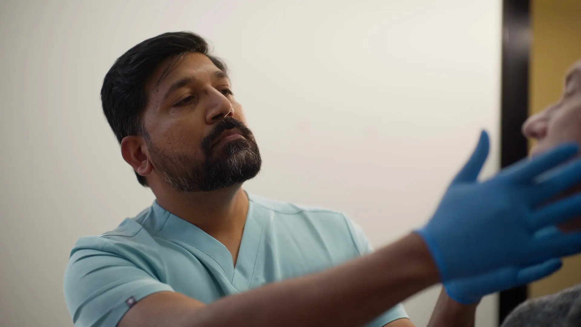 Dr Sri examining a patient's jaw at Dental Embassy in Braddon