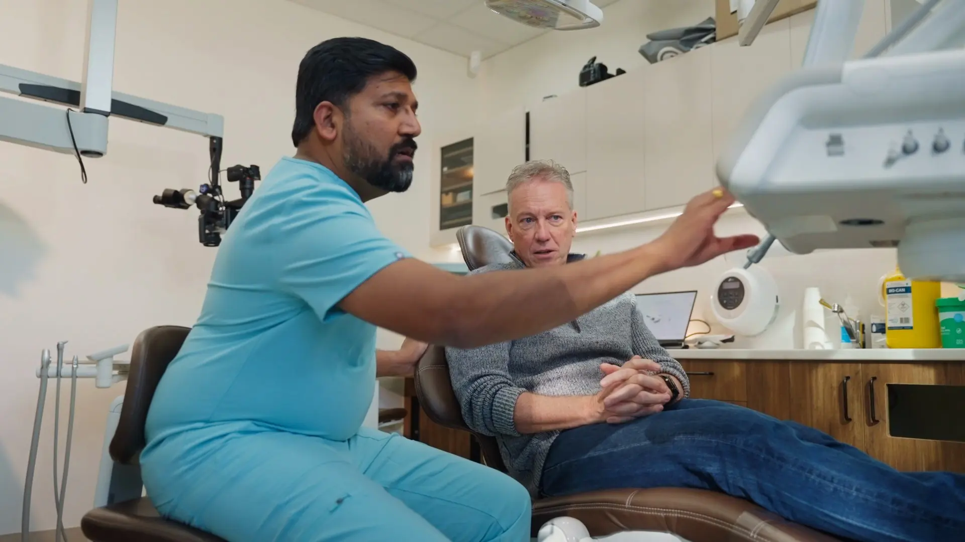 Dr Sri explaining treatment options to a patient in the chair