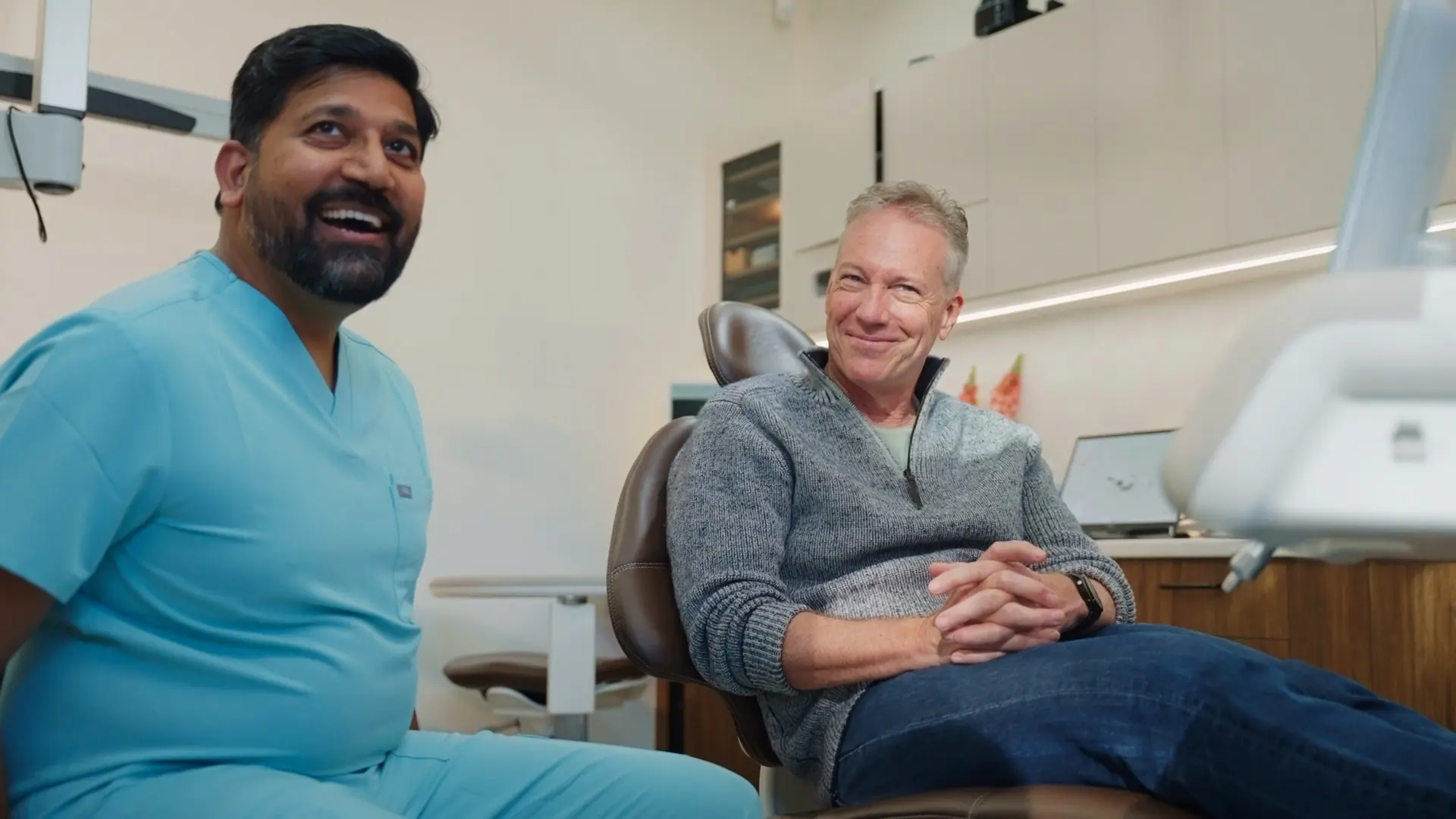 Dr Sri and a patient laughing together during a consultation