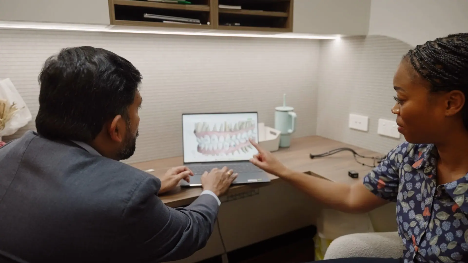 Dr Sri and a patient looking at a treatment plan on a laptop