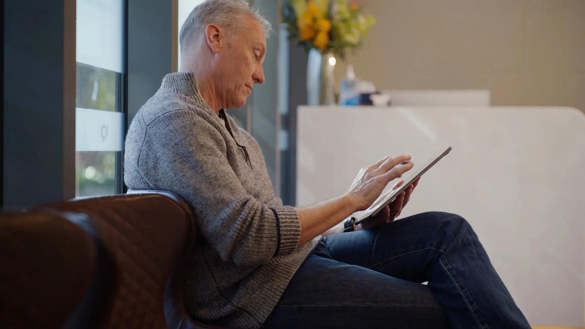 A patient waiting in reception with a tablet