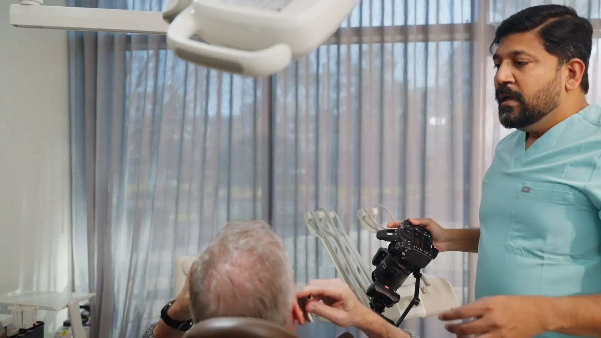 Dr Sri taking clinical photos of a patient by the window